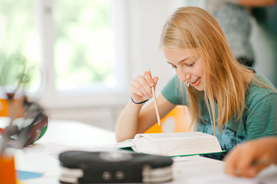 Mädchen studiert Wörterbuch im Lernwerk Sprachkurs