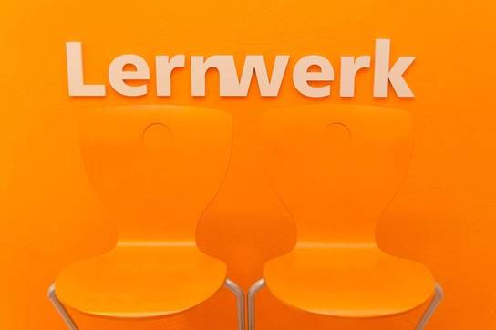 Lernwerk steglitz - zwei Stühle vor Lernwerk Logo